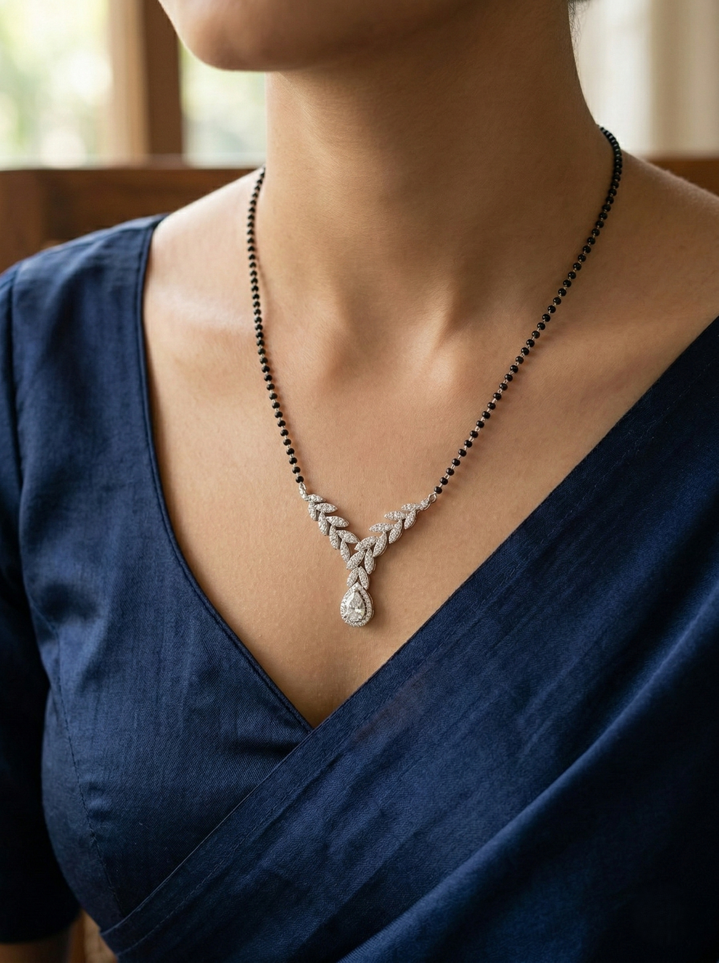 elegant silver-tone leaf design mangalsutra with green teardrop crystal and black beaded chain