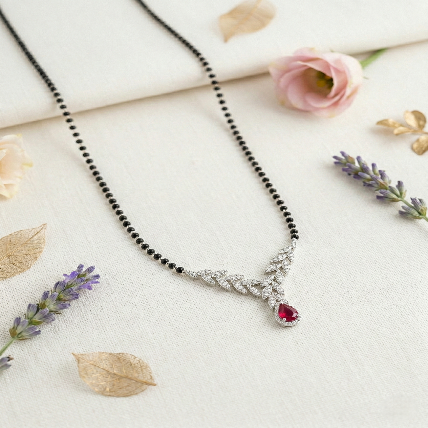 elegant silver-tone leaf design mangalsutra with green teardrop crystal and black beaded chain