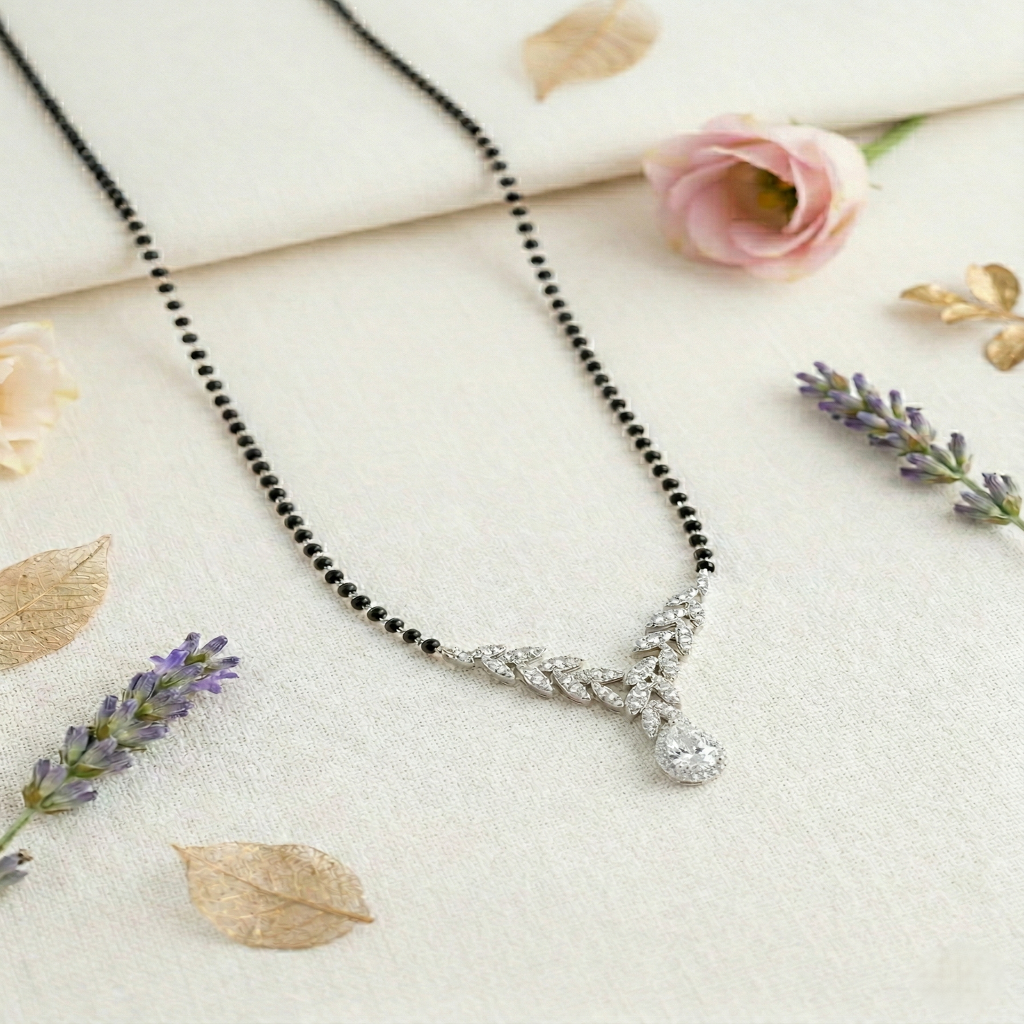 elegant silver-tone leaf design mangalsutra with green teardrop crystal and black beaded chain